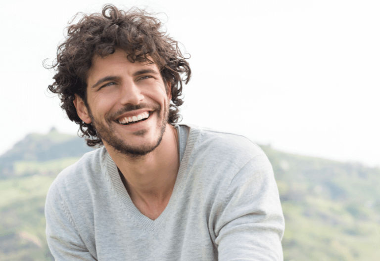 Man with orthodontics smiling at Crescent Lodge Dental Practice in Clapham