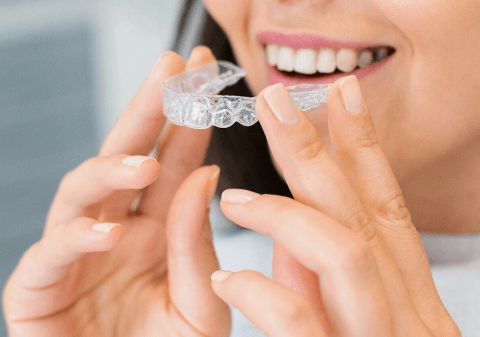 woman putting in invisalign braces at Crescent Lodge Dental Practice in Clapham