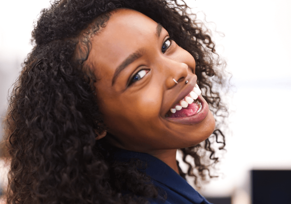 woman with cosmetic dental treatments smiling whilst looking backward