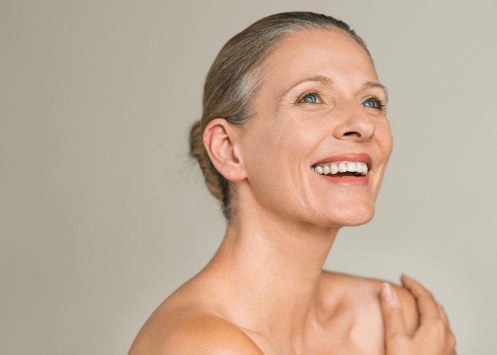 An older woman smiling after she has received an emergency dental appointment
