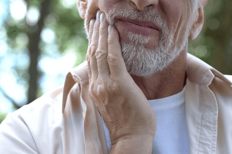 Man holding jaw in pain as he is in need of an emergency dental appointment.