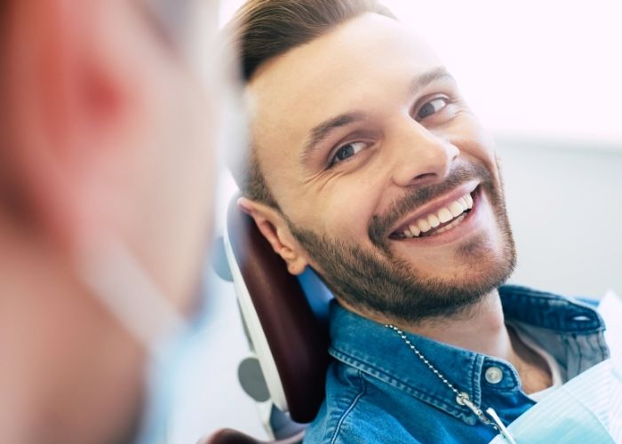 Man smiling at his dentist after undergoing emergency dental treatment.