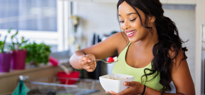  Dark-haired woman in sportswear eating a healthy breakfast