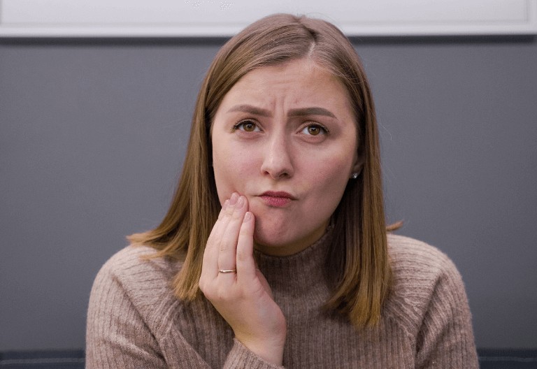 woman in pain from toothache in need of an emergency dentist appointment.