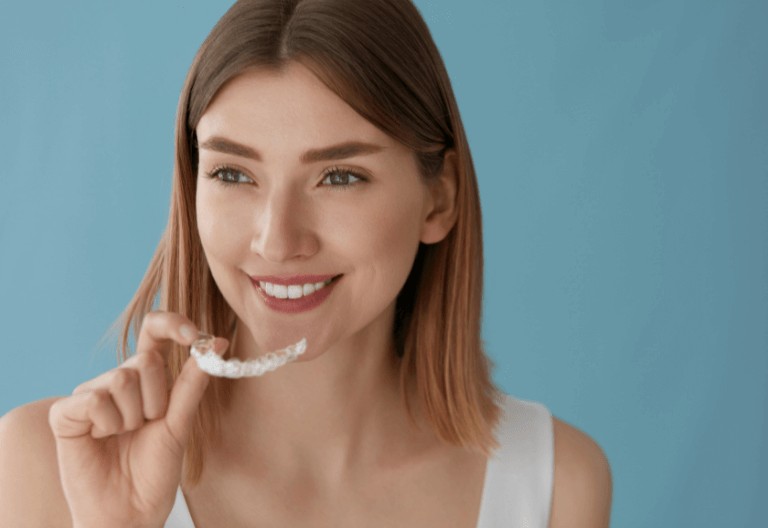 brunette woman holding Invisalign braces