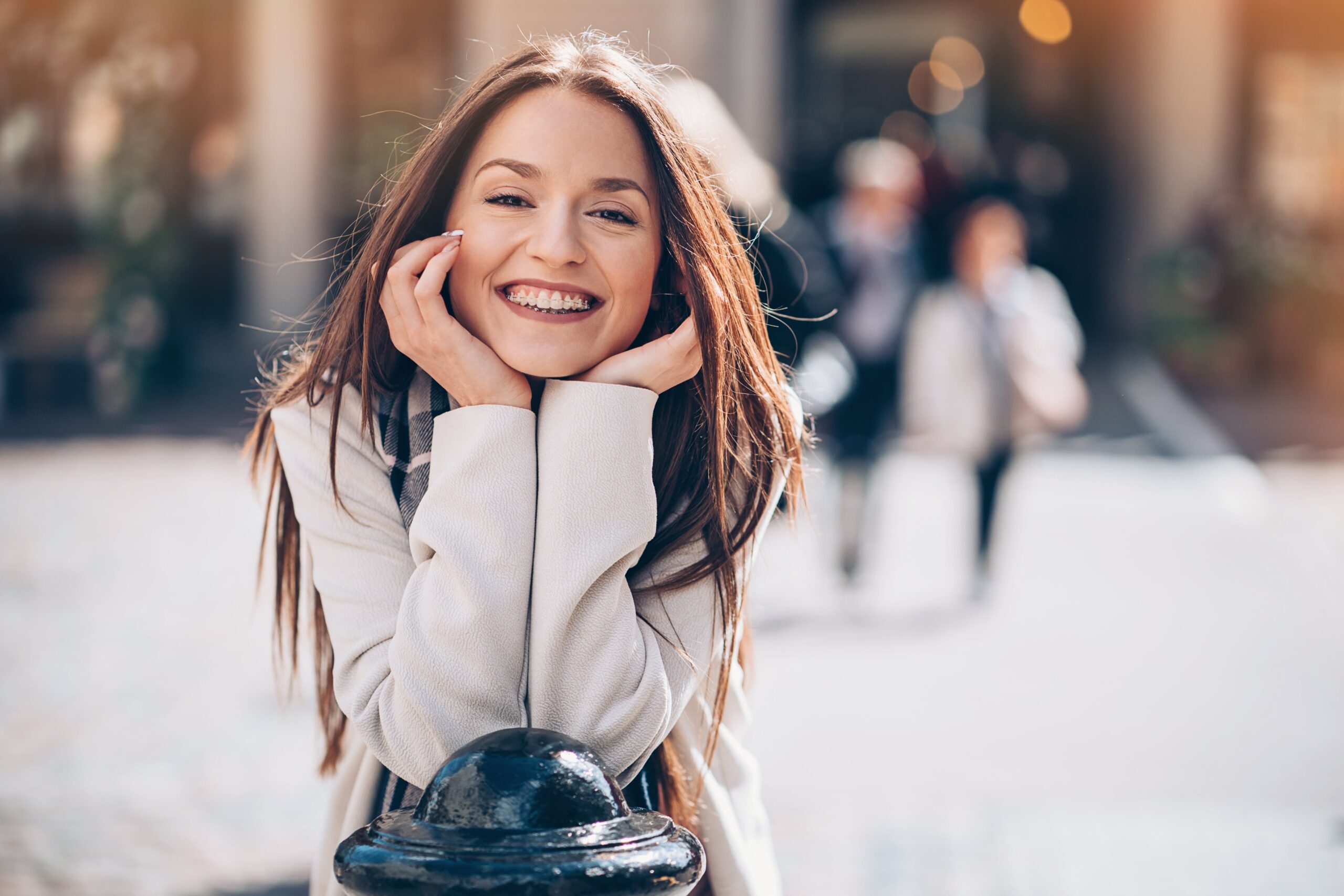 Woman wearing braces smiling at the camera. She got her adult braces here at Crescent Lodge Dental Practice.