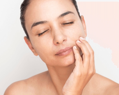 Woman holding her cheek in pain after a broken tooth